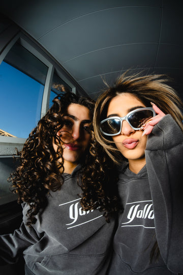 Two women wearing Yalla Apparel’s Arab Clothing hoodies — showcasing modern Middle Eastern fashion and streetwear style.