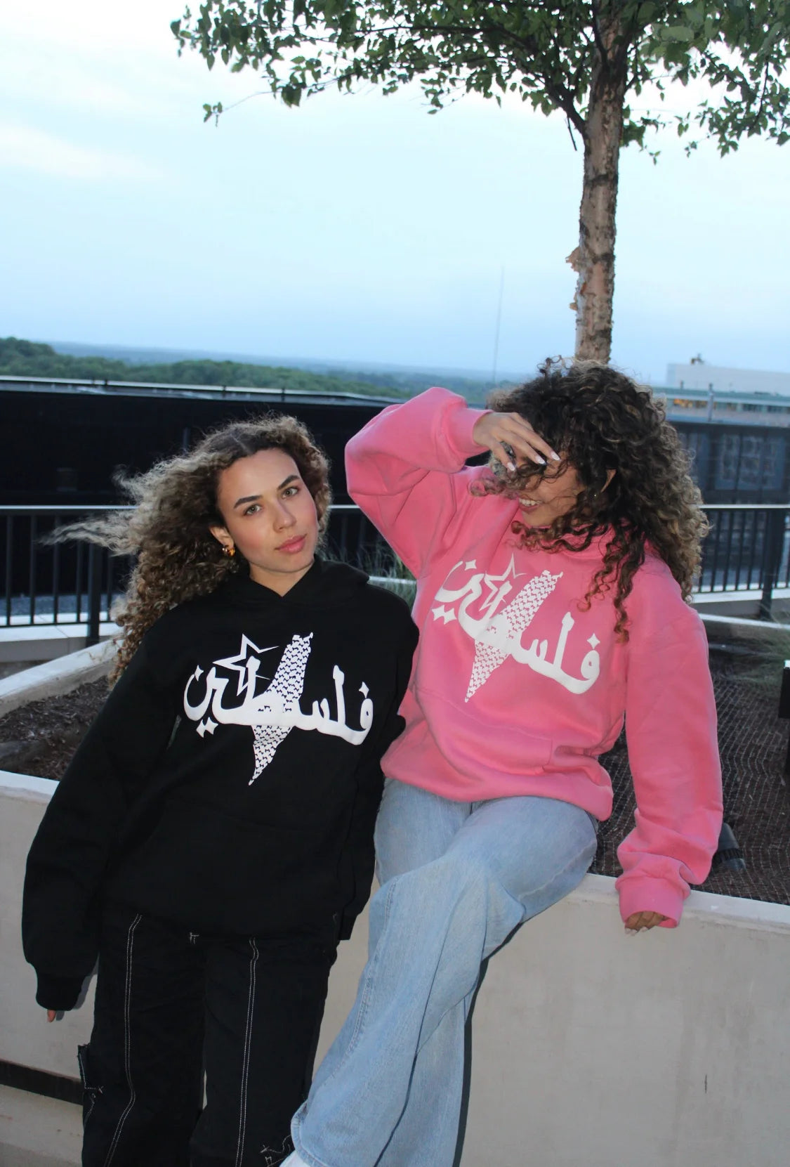 Two women styling the Peace Pink Hoodie, blending Arab streetwear with cultural heritage fashion.